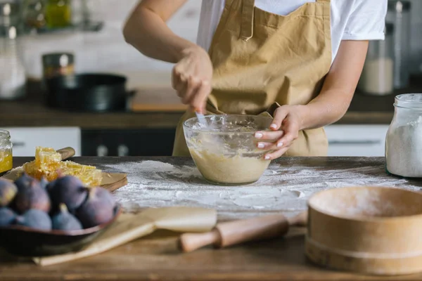 Colpo ritagliato di donna che mescola la pasta per torta su tavolo di legno rustico — Foto stock