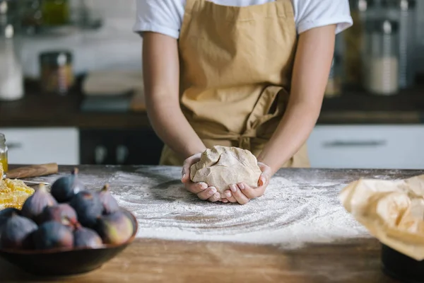 Abgeschnittene Aufnahme einer Frau, die Teig für Kuchen auf rustikalem Holztisch hält — Stockfoto