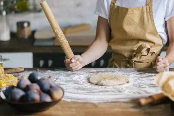 Abgeschnittene Aufnahme einer Frau, die mit Nudelholz Teig für Kuchen auf rustikalem Holztisch zubereitet — Stockfoto