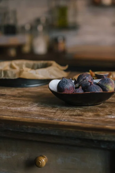 Close-up shot of bowl of fresh figs on rustic wooden table — Stock Photo