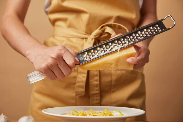Tiro cortado de mulher ralando queijo em espaguete — Fotografia de Stock