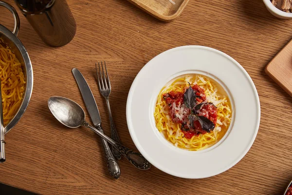 Draufsicht auf köstliche Pasta und eine Flasche Wein auf einem Holztisch — Stockfoto