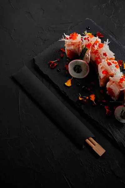 Gourmet roll in mamenori with shrimp, salmon and avocado on slate board and chopsticks — Stock Photo