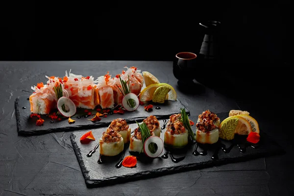 Vista de cerca de deliciosos rollos de sushi tradicionales frescos en pizarras - foto de stock