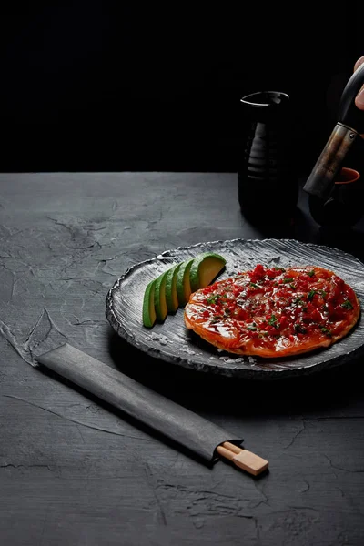 Okonomiyaki, panqueque salado tradicional japonés con aguacate en rodajas y pescado con salsa - foto de stock