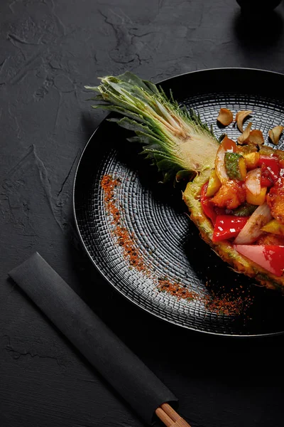 Vue rapprochée de délicieux plats japonais servis en tranches d'ananas et baguettes — Photo de stock