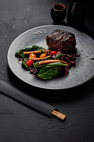 Close-up view of gourmet roasted meat in Teriyaki sauce with grilled cherry tomatoes, red cabbage and leaves of spinach, baby corn and kumquat — Stock Photo