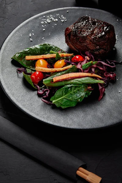 Vista close-up de deliciosa carne em molho Teriyaki com tomates cereja grelhados, repolho vermelho e folhas de espinafre, milho bebê e kumquat — Fotografia de Stock