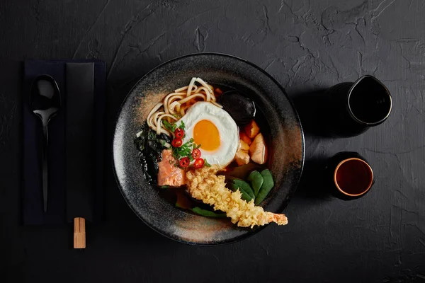 Vista superior del tazón con sopa gourmet japonesa con huevo, fideos y champiñones - foto de stock