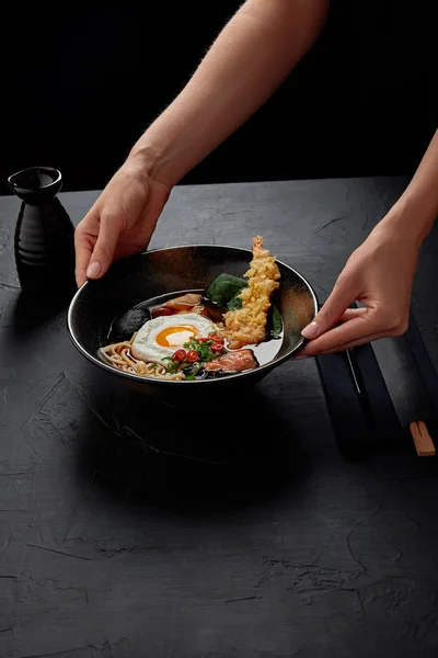 Plan recadré d'une personne tenant un bol avec une délicieuse soupe japonaise traditionnelle — Photo de stock