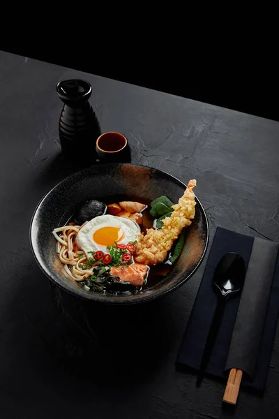 Vista de ángulo alto de deliciosa sopa japonesa tradicional en tazón con palillos y cuchara - foto de stock