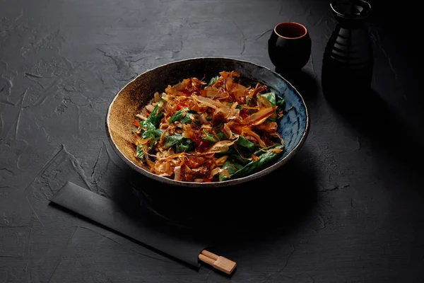 Vista de ángulo alto de delicioso plato japonés en plato y palillos - foto de stock