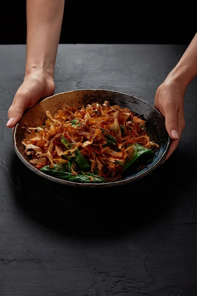 Обрізаний знімок людини, що тримає тарілку зі смачною японською стравою з кацуобусі, сушеною стружкою боніто — стокове фото