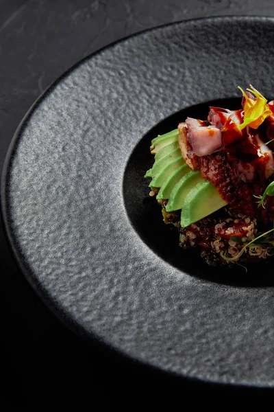 Vue rapprochée de délicieux plats japonais traditionnels avec fruits de mer, avocat et herbes sur plaque noire — Photo de stock