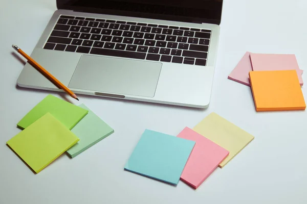 Laptop, Notizpapier und Bleistift auf weißer Tischplatte — Stockfoto