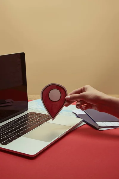 Cropped image of woman holding location sign near laptop — Stock Photo