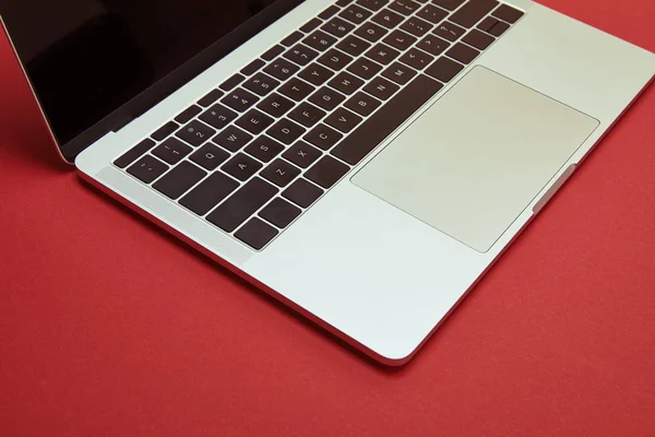 One open laptop on red tabletop — Stock Photo