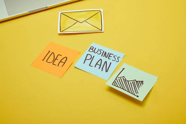 Paper stickers with words, idea and business plan on yellow surface — Stock Photo
