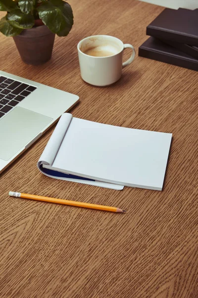 Computer portatile, notebook e matita su tavolo marrone in legno — Foto stock