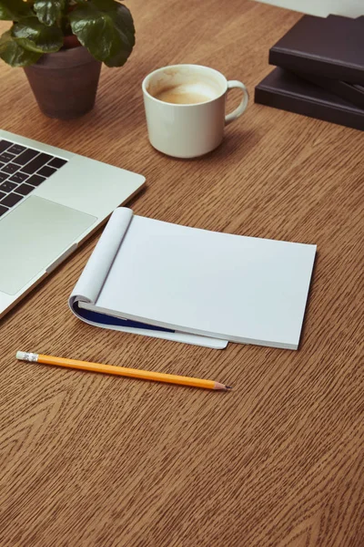 Laptop, notebook and pencil on wooden brown tabletop — Stock Photo