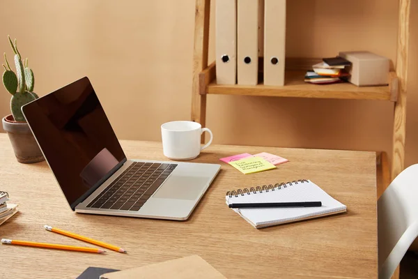 Computer portatile, quaderni e matite su tavolo in legno a casa — Foto stock