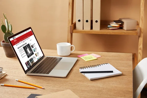 Laptop mit geladener bbc-Nachrichtenseite auf Holztisch zu Hause — Stockfoto