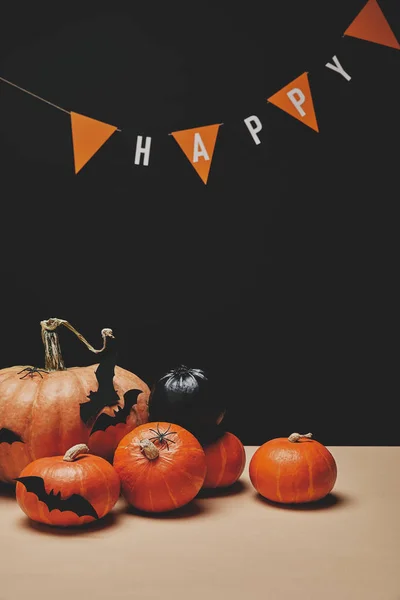 Calabazas, murciélagos de papel y guirnalda de papel con la palabra feliz, concepto de Halloween - foto de stock