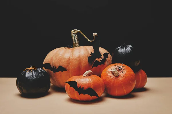 Calabazas naranjas y negras con murciélagos de papel en la mesa, concepto de Halloween - foto de stock