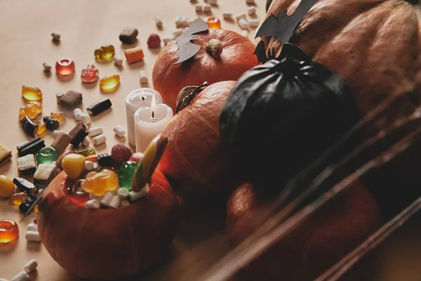 Vue grand angle des citrouilles d'Halloween, bonbons à la gelée et chauves-souris en papier sur la table — Photo de stock