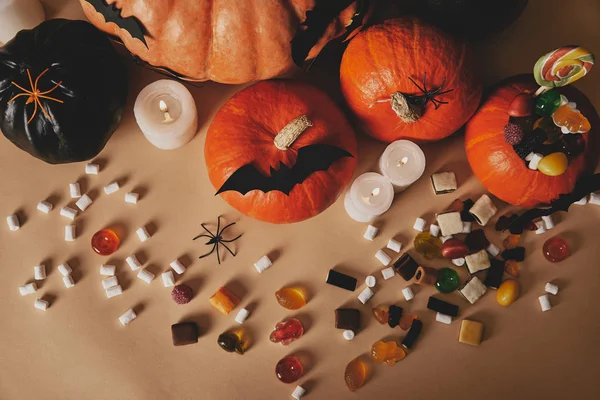 Top view of pumpkins, jelly candies and paper bats on table, halloween concept — Stock Photo