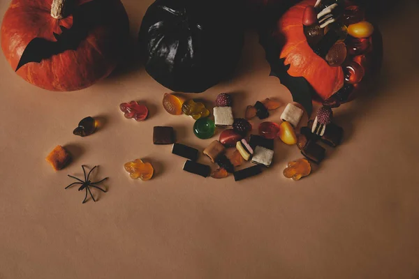 Hochwinkelaufnahme von Kürbissen, Papierfledermäusen und Gelee Bonbons auf dem Tisch, Halloween-Konzept — Stockfoto