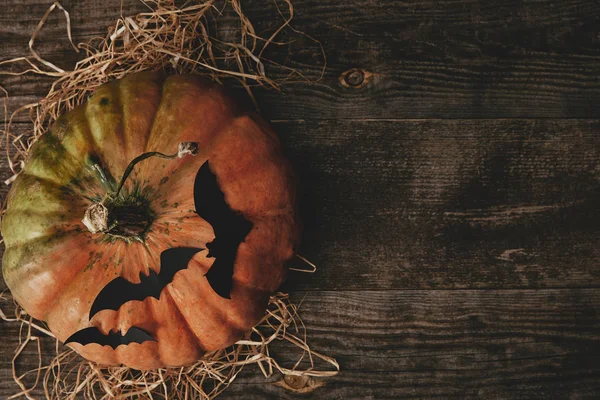 Draufsicht auf Kürbis und Papierfledermäuse auf Holztisch, Halloween-Konzept — Stockfoto