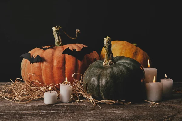 Zucche, candele e pipistrelli di carta sul tavolo di legno, concetto di Halloween — Foto stock