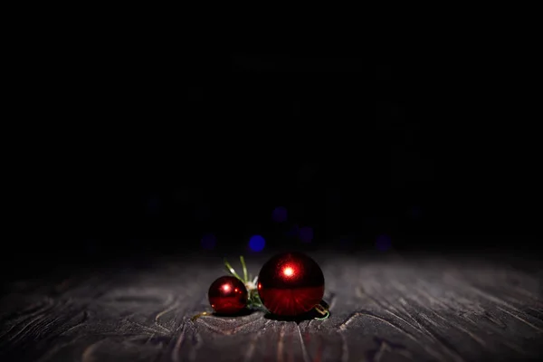 Red christmas balls on wooden table with black background — Stock Photo