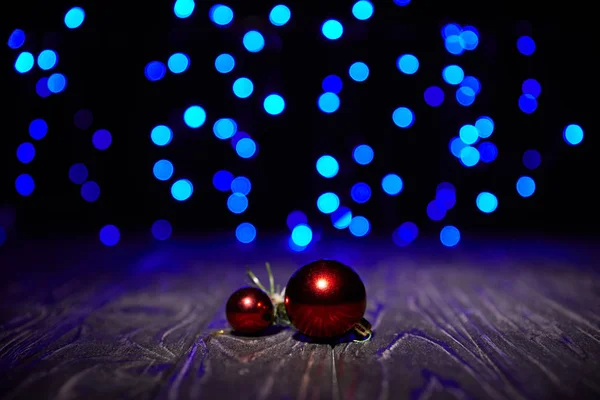 Palline di Natale rosse su tavolo di legno con sfondo blu lucido — Foto stock