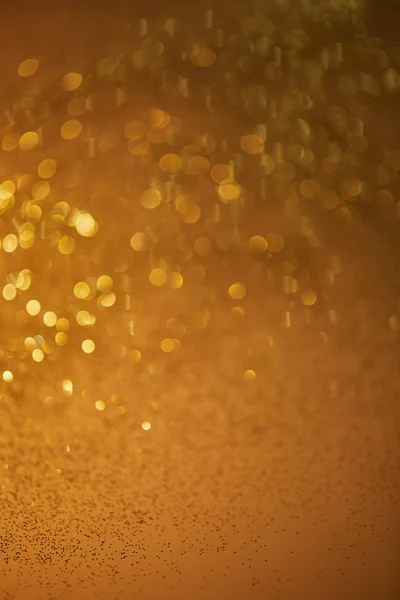 Golden bokeh christmas background with falling glittering sequins — Stock Photo