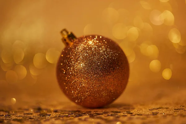 Golden glossing christmas ball for decoration on tabletop — Stock Photo