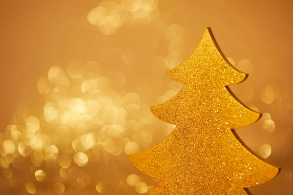 Golden glittering christmas tree for decoration on blurred background — Stock Photo