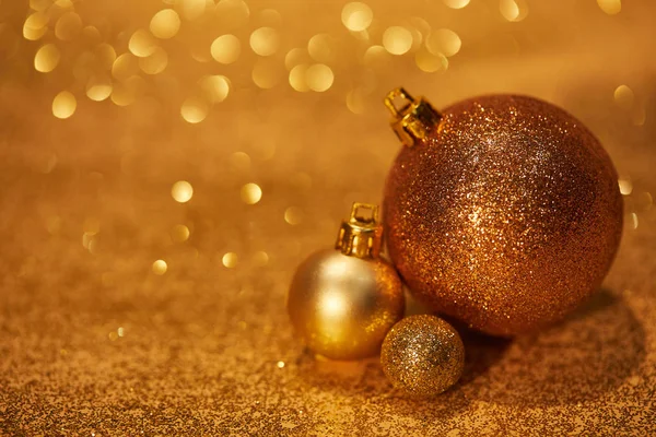Golden shiny decorative christmas balls on tabletop with sequins — Stock Photo
