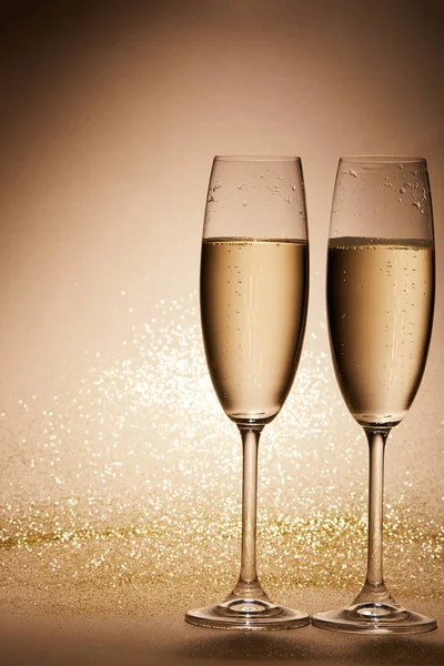 Two glasses of champagne with glitter on tabletop, christmas concept — Stock Photo