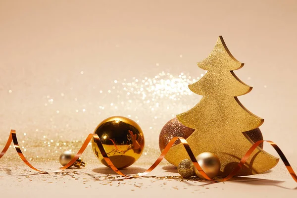 Bolas de navidad, árbol de navidad decorativo, cinta ondulada y brillo en la mesa - foto de stock