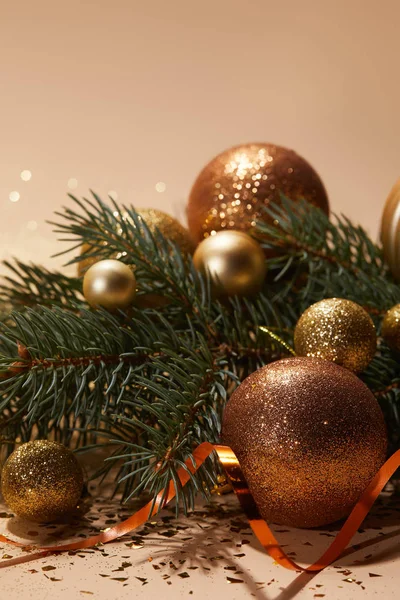 Bolas de Natal brilhantes no ramo de pinho na mesa — Fotografia de Stock