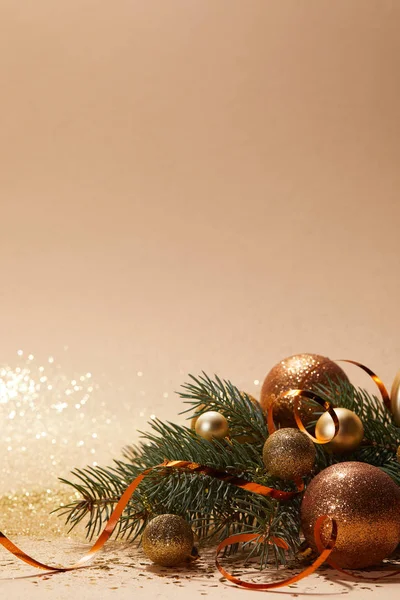 Brillantes bolas de navidad doradas y rama de árbol de navidad en la mesa — Stock Photo