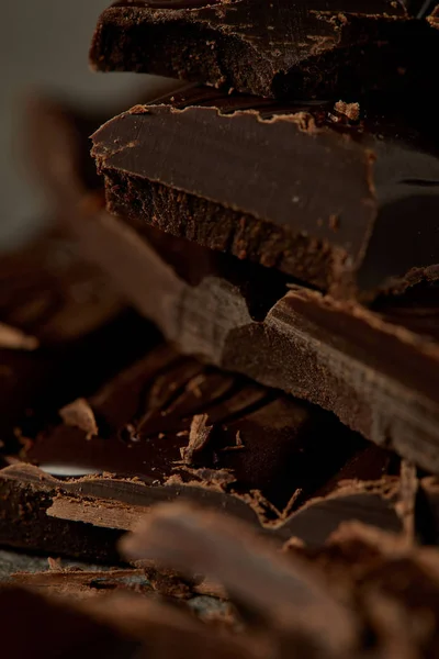 Крупный план изысканных вкусных кусочков шоколада, шоколадный фон — стоковое фото