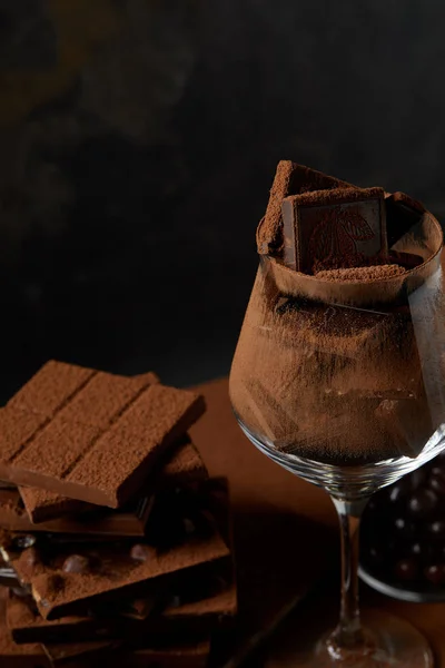 Nahaufnahme von Glas und köstlich sortierten Schokoladenstücken auf schwarz — Stockfoto