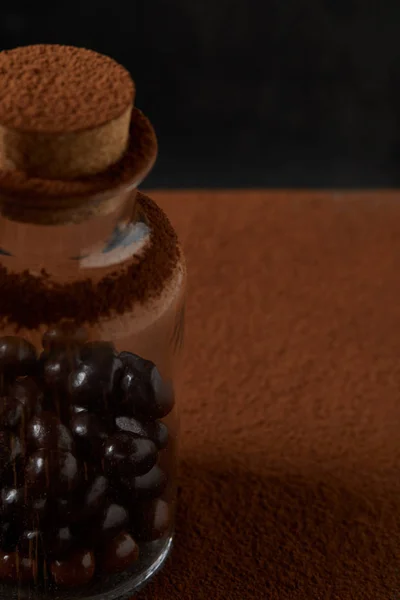 Close-up view of gourmet chocolate balls in glass jar and cocoa powder — Stock Photo