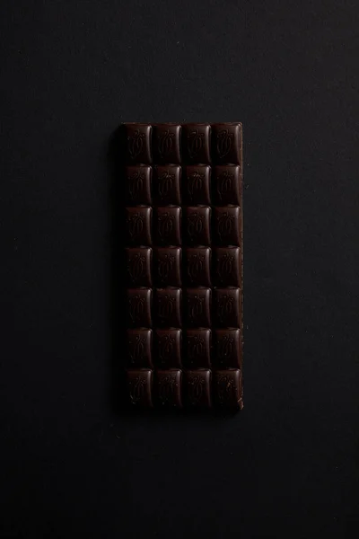Vista superior da barra gourmet de chocolate isolado em preto — Fotografia de Stock