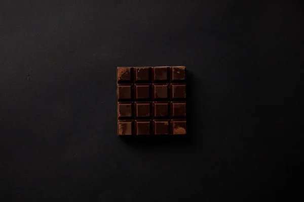 Vue du dessus du chocolat sucré gastronomique sur fond noir — Photo de stock