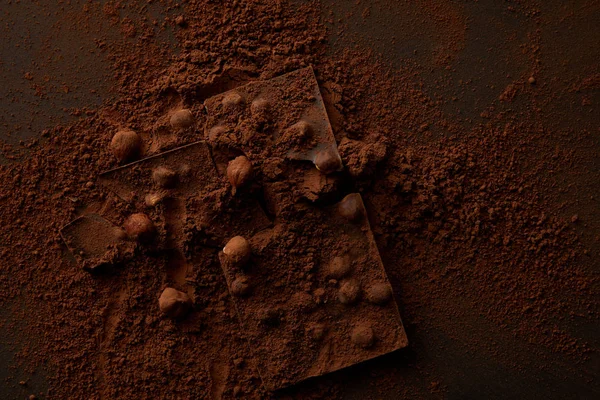 Top view of delicious chocolate pieces with nuts on dark background — Stock Photo