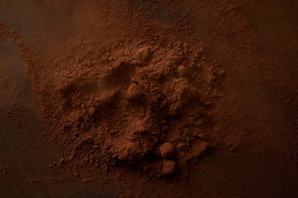 Vista superior del delicioso cacao en polvo sobre fondo oscuro - foto de stock